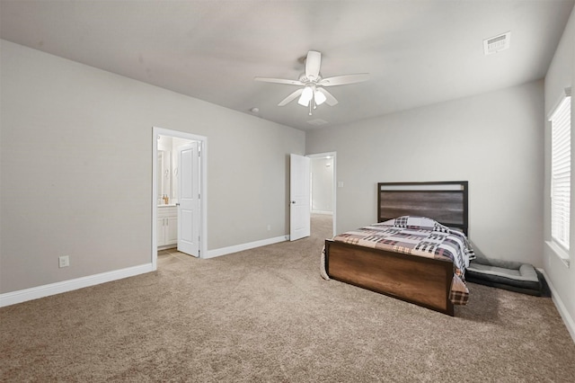 carpeted bedroom with ensuite bath and ceiling fan