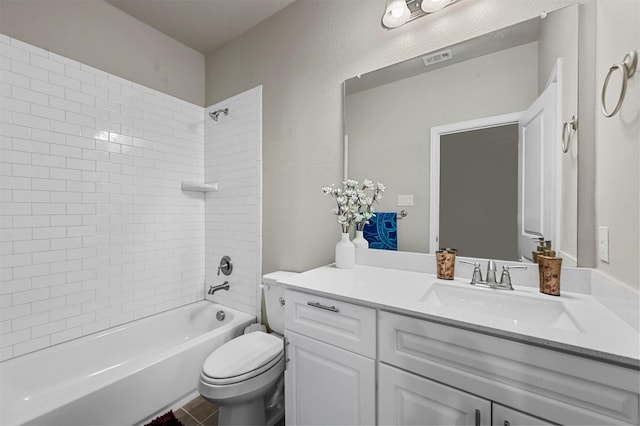 full bathroom featuring vanity, tiled shower / bath combo, and toilet