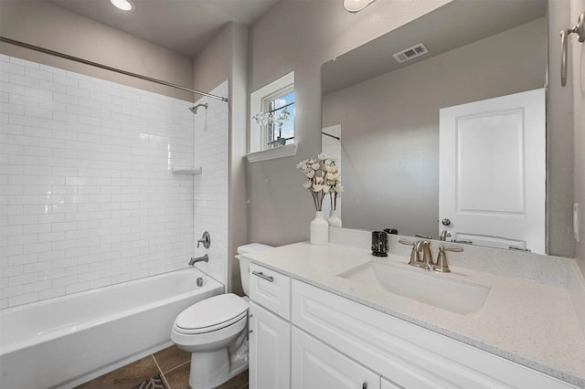 full bathroom with tile patterned flooring, vanity, tiled shower / bath combo, and toilet