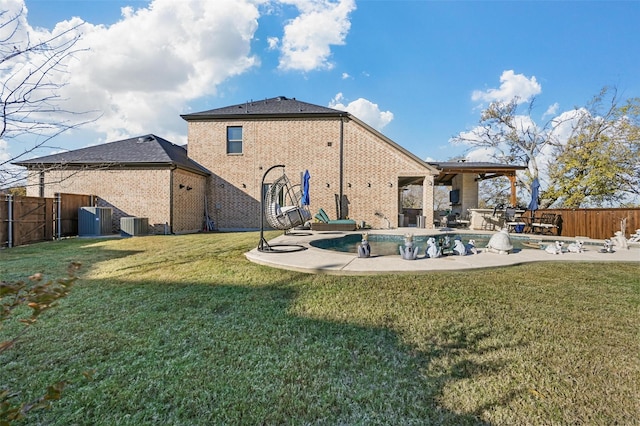 rear view of house featuring a yard, cooling unit, a patio, and a swimming pool