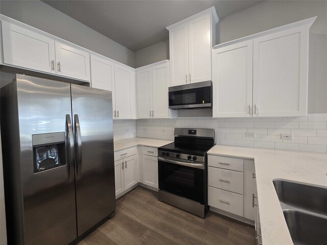 kitchen featuring white cabinetry, sink, stainless steel appliances, dark hardwood / wood-style flooring, and backsplash