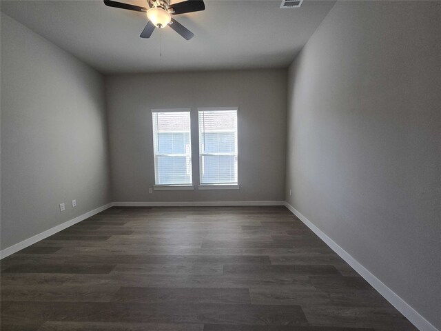 empty room with ceiling fan and dark hardwood / wood-style flooring