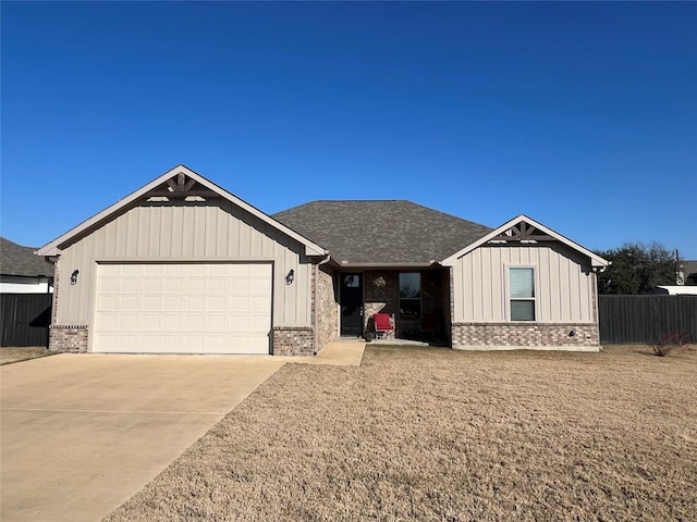 view of front of property featuring a garage, concrete driveway, brick siding, and board and batten siding