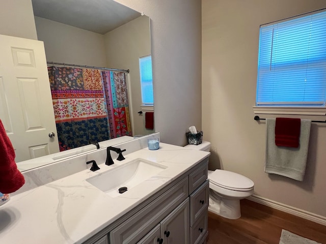 bathroom featuring wood-type flooring, toilet, vanity, and a shower with curtain