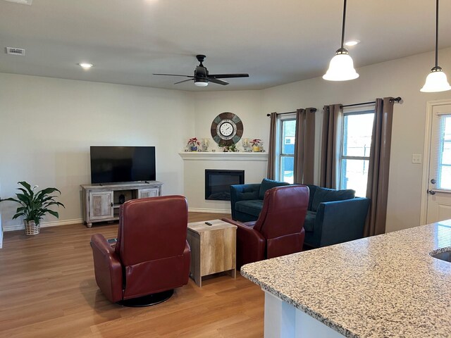 kitchen featuring appliances with stainless steel finishes, sink, decorative light fixtures, white cabinets, and light stone counters