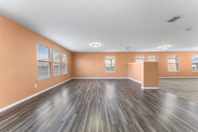 spare room featuring plenty of natural light and dark wood-type flooring