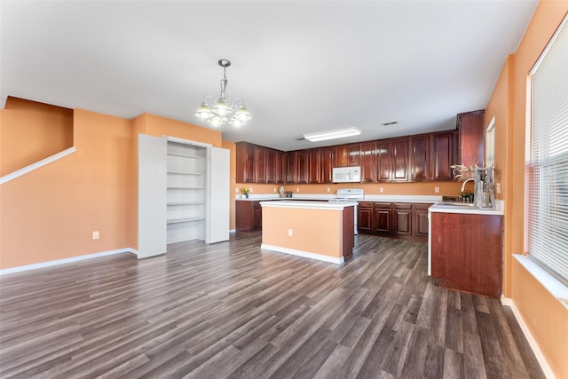 kitchen featuring a center island, white appliances, hanging light fixtures, dark hardwood / wood-style floors, and a chandelier