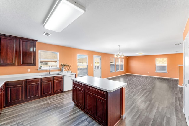 kitchen featuring white dishwasher, pendant lighting, sink, and light hardwood / wood-style flooring