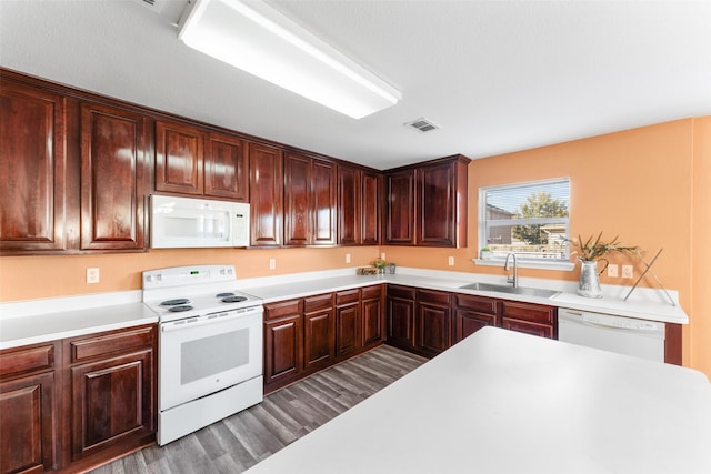 kitchen with dark hardwood / wood-style flooring, white appliances, and sink