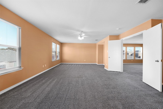 carpeted spare room featuring ceiling fan and a wealth of natural light