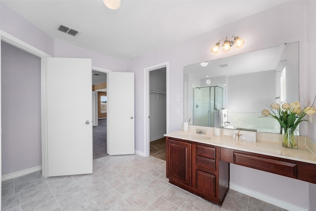 bathroom featuring tile patterned flooring, vanity, and a shower with door