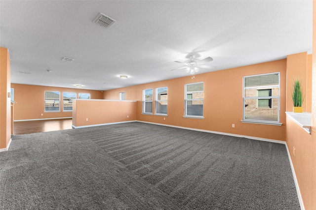 carpeted spare room with a wealth of natural light and ceiling fan