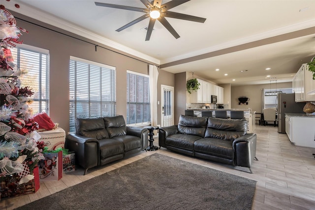 living room with ceiling fan and ornamental molding