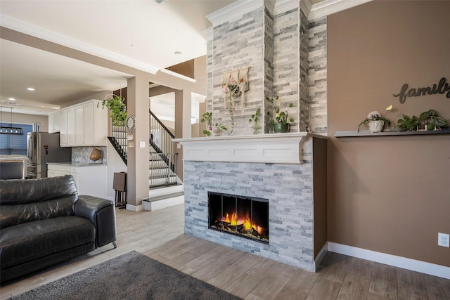 living room featuring ornamental molding and a tiled fireplace