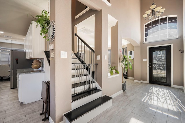 entryway featuring a notable chandelier and a high ceiling