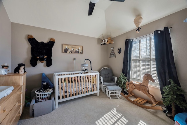 bedroom with ceiling fan, lofted ceiling, light carpet, and a nursery area