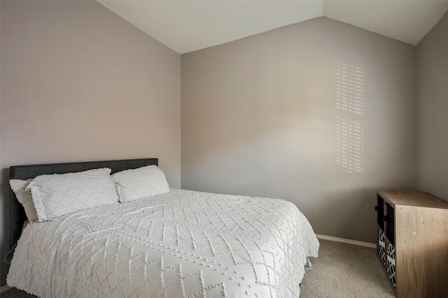 bedroom with light carpet and lofted ceiling