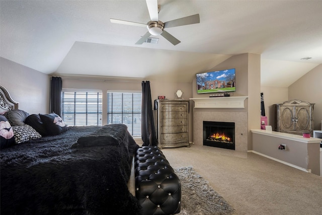 bedroom with carpet, vaulted ceiling, ceiling fan, and a fireplace