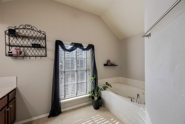 bathroom featuring a tub to relax in, tile patterned flooring, vanity, and lofted ceiling