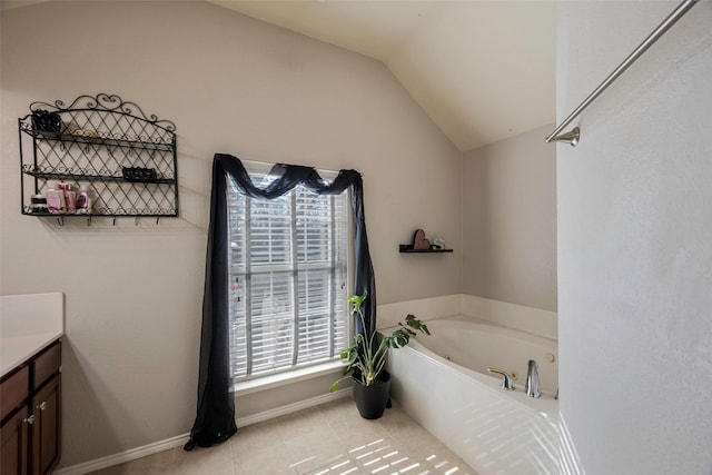 bathroom with lofted ceiling, tile patterned flooring, a bathtub, and vanity