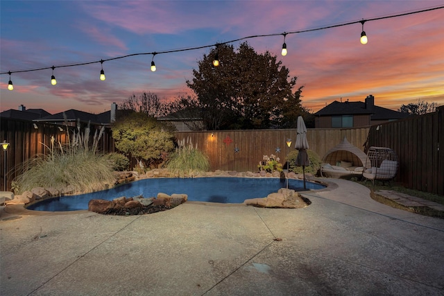 pool at dusk with a patio