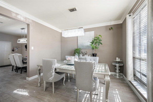 dining space featuring a chandelier, a wealth of natural light, and crown molding