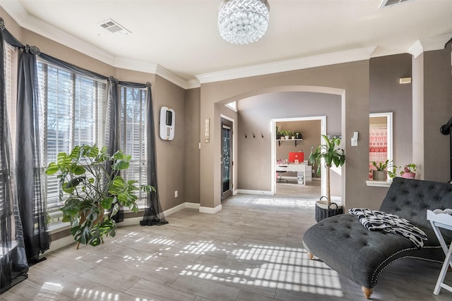 interior space with light tile patterned floors, ornamental molding, and an inviting chandelier