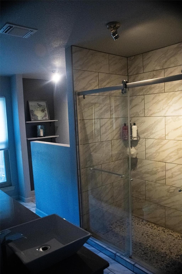 bathroom with a shower with door