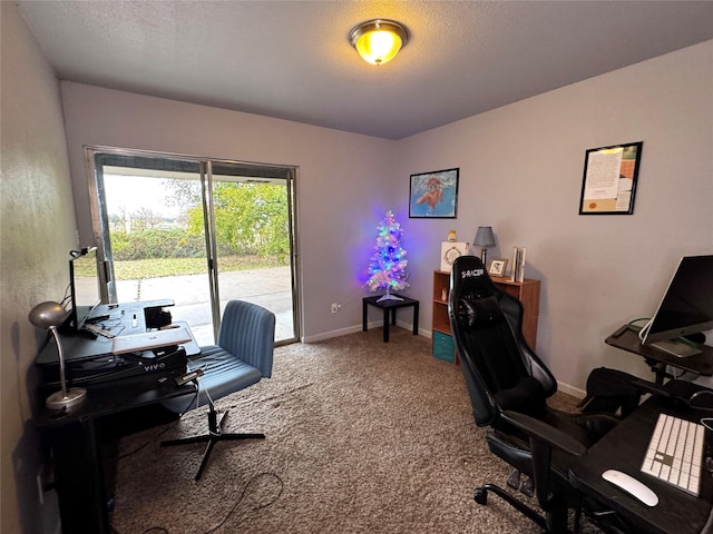 carpeted home office featuring a textured ceiling