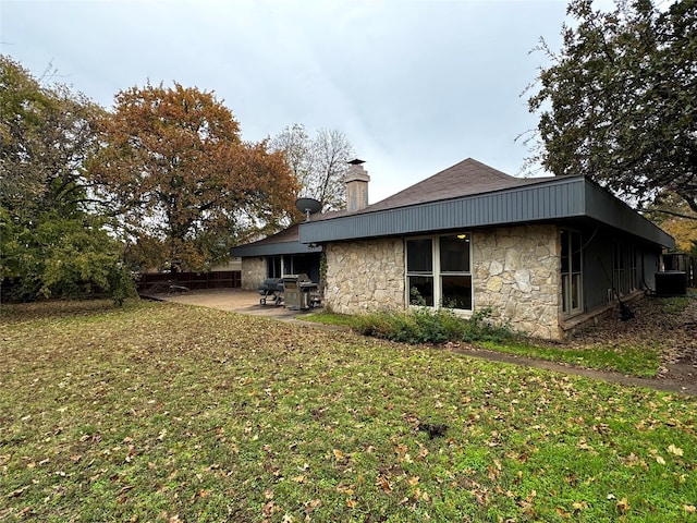 rear view of property with a yard, a patio, and central AC unit