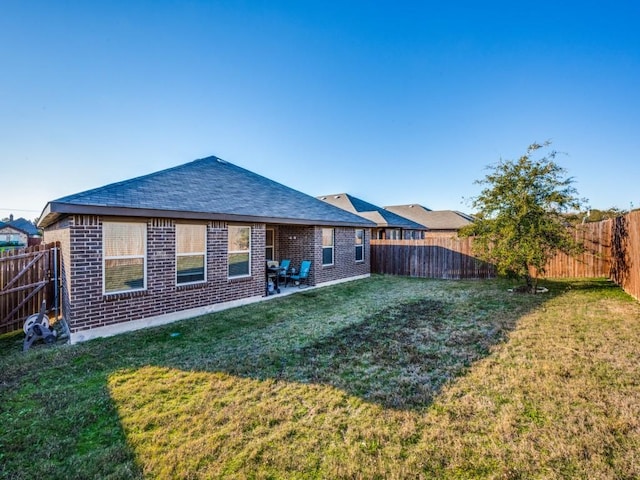 rear view of property featuring a lawn and a patio area