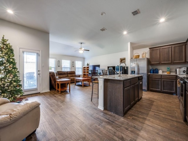 kitchen with a kitchen breakfast bar, a kitchen island with sink, sink, stainless steel fridge with ice dispenser, and dark hardwood / wood-style floors