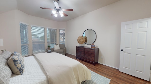 bedroom with access to exterior, ceiling fan, dark hardwood / wood-style flooring, and vaulted ceiling