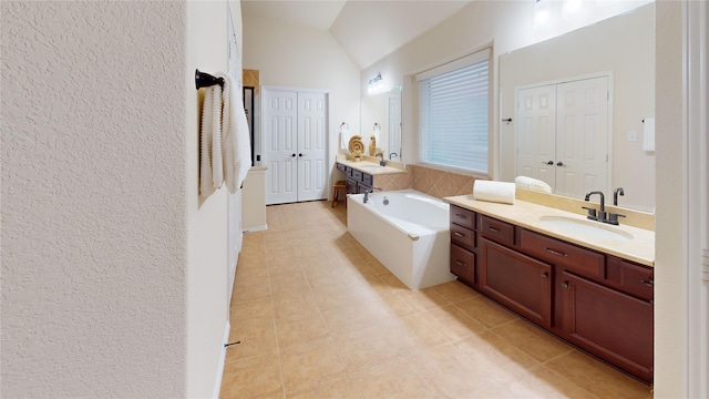 bathroom with tile patterned flooring, vanity, and lofted ceiling