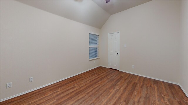 unfurnished room with dark hardwood / wood-style floors and vaulted ceiling