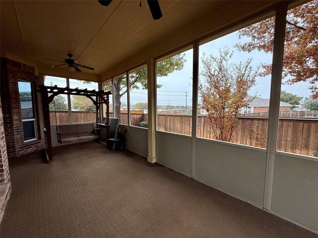 unfurnished sunroom featuring ceiling fan