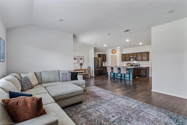 living room featuring dark hardwood / wood-style flooring and vaulted ceiling