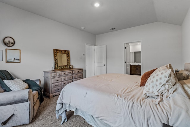 carpeted bedroom featuring ensuite bathroom and vaulted ceiling