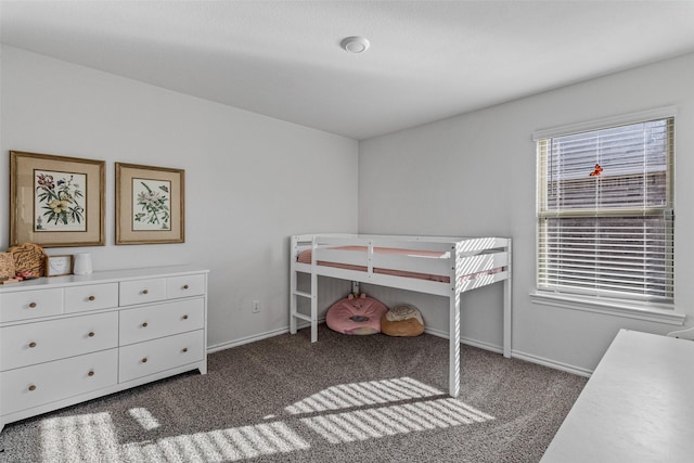 bedroom featuring dark carpet and multiple windows