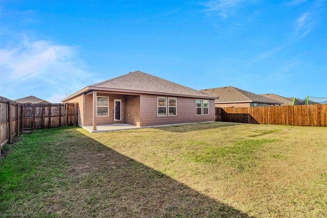 rear view of house with a yard and a patio