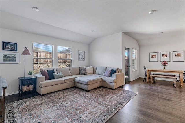 living room featuring dark wood-type flooring and vaulted ceiling