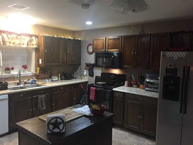 kitchen featuring black appliances, dark brown cabinets, and sink