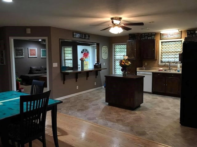 kitchen featuring dark brown cabinetry, ceiling fan, dishwasher, sink, and black fridge