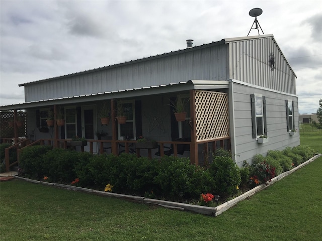 rear view of house featuring a porch and a yard