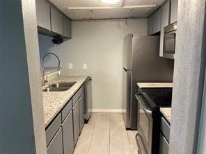 kitchen featuring stainless steel appliances, gray cabinetry, and sink