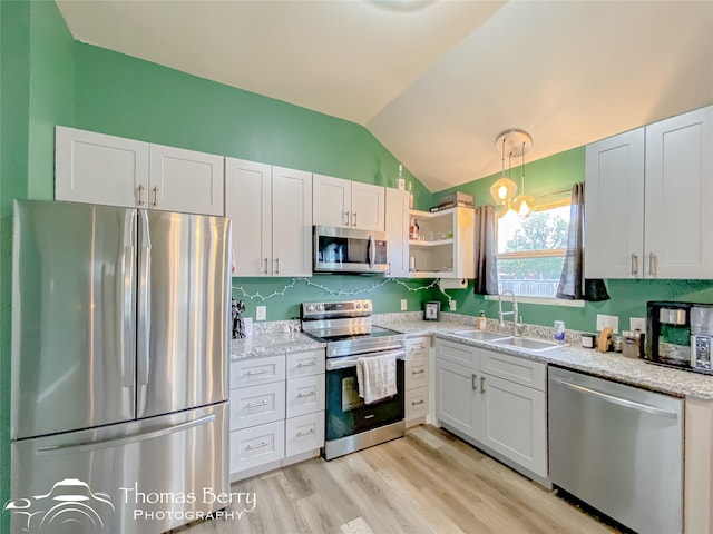 kitchen with sink, vaulted ceiling, light hardwood / wood-style floors, white cabinetry, and stainless steel appliances