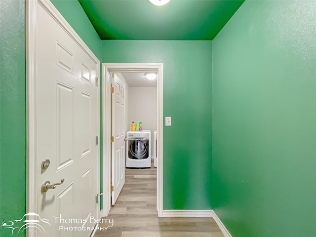 hallway featuring washer and clothes dryer and light hardwood / wood-style flooring