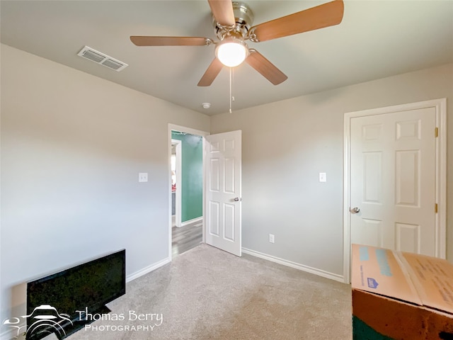 interior space featuring ceiling fan and light colored carpet