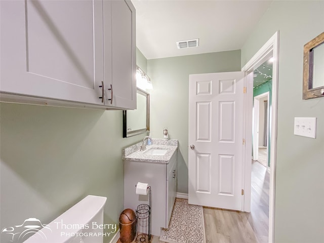 bathroom with vanity, hardwood / wood-style flooring, and toilet