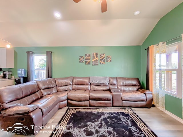 living room with lofted ceiling, ceiling fan, and light wood-type flooring